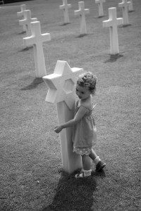 Willow hugging grave Omaha war memorial My daughter hugging the graves at Omaha